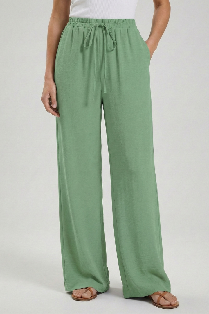 Light blue women’s palazzo trousers with drawstring waist and side pockets by THE WHITMORE FAMILY, casual and comfortable fit.