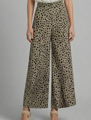 Women’s pink palazzo trousers with high waist and polka dot pattern by THE WHITMORE FAMILY, shown on a model.