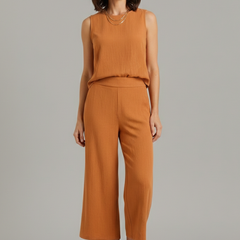 Beige women's two-piece set with sleeveless top and cropped trousers by THE WHITMORE FAMILY, styled for modern casual wear.