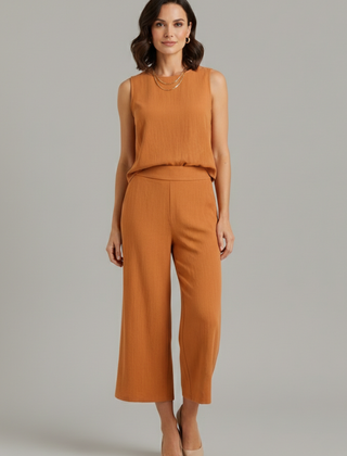 Beige women's two-piece set with sleeveless top and cropped trousers by THE WHITMORE FAMILY, styled for modern casual wear.