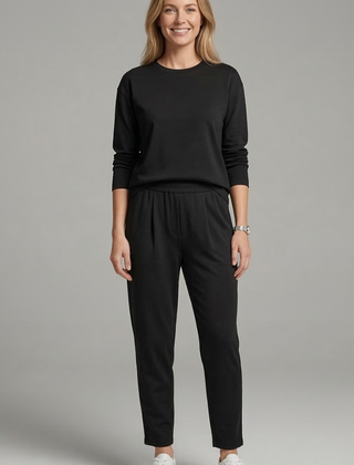 Women’s black two-piece set with crew neck top and tapered trousers from THE WHITMORE FAMILY, styled on a model.