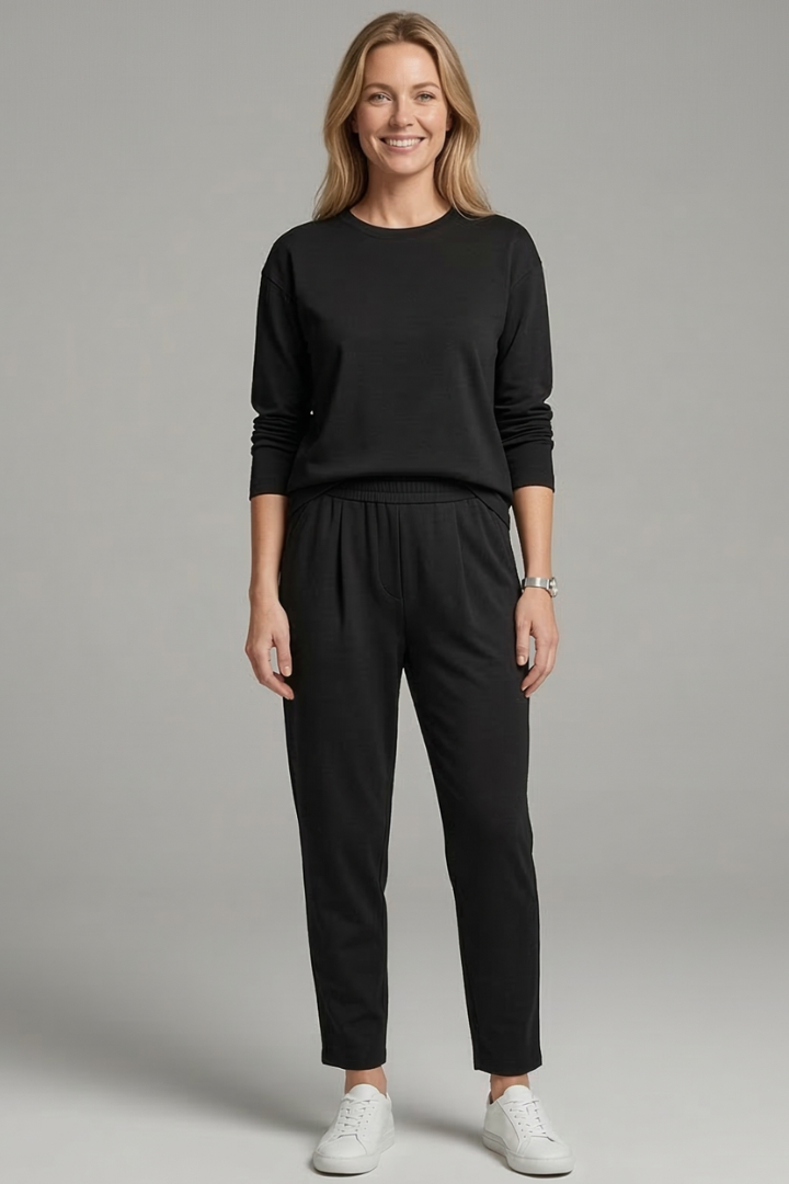Women’s black two-piece set with crew neck top and tapered trousers from THE WHITMORE FAMILY, styled on a model.