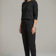 Women’s black two-piece set by THE WHITMORE FAMILY, featuring a crew neck top and tapered trousers, shown on a model.
