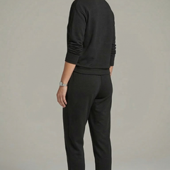 Women’s black two-piece set by THE WHITMORE FAMILY featuring a crew neck top and tapered trousers, styled on a model.