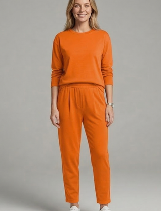 Women’s black two-piece set by THE WHITMORE FAMILY, featuring a crew neck top and tapered trousers, styled for casual wear.