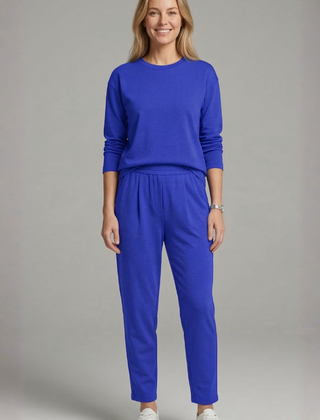 Women’s black two-piece set by THE WHITMORE FAMILY featuring a crew neck top and tapered trousers, displayed on a model.