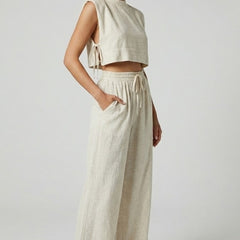 Cream women's two-piece set with sleeveless top and wide-leg pants from THE WHITMORE FAMILY, styled for casual elegance.