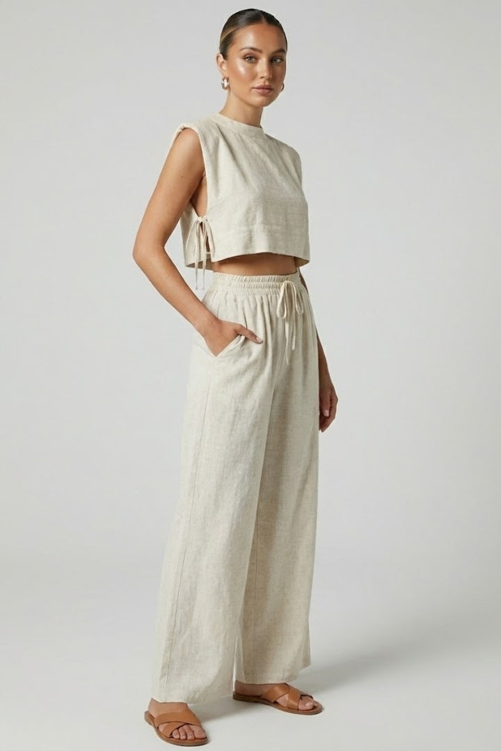 Cream women's two-piece set with sleeveless top and wide-leg pants from THE WHITMORE FAMILY, styled for casual elegance.