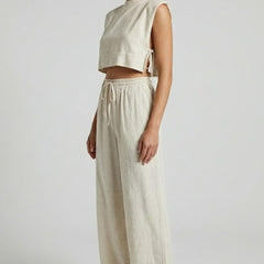 Cream women's two-piece set with sleeveless top and wide-leg pants from THE WHITMORE FAMILY, styled for casual wear.