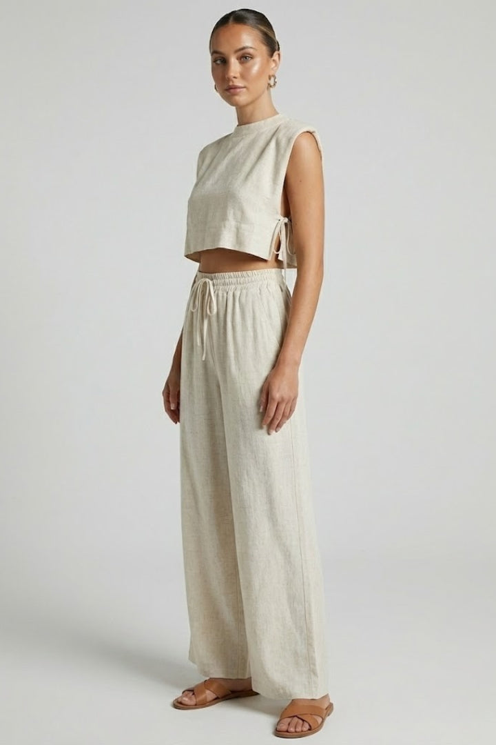 Cream women's two-piece set with sleeveless top and wide-leg pants from THE WHITMORE FAMILY, styled for casual wear.