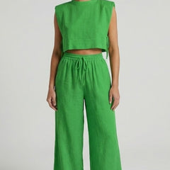 Cream women's two-piece set with sleeveless top and wide-leg pants by THE WHITMORE FAMILY, shown on a model.