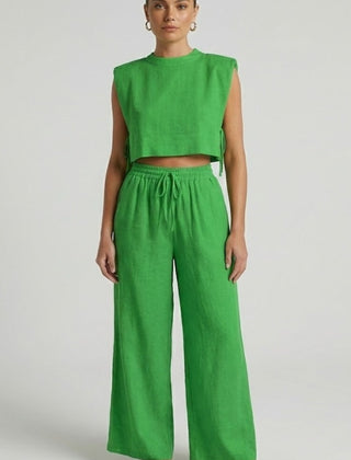 Cream women's two-piece set with sleeveless top and wide-leg pants by THE WHITMORE FAMILY, shown on a model.