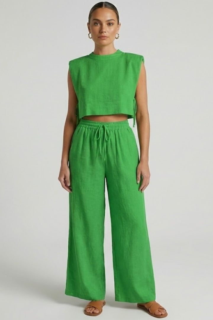 Cream women's two-piece set with sleeveless top and wide-leg pants by THE WHITMORE FAMILY, shown on a model.