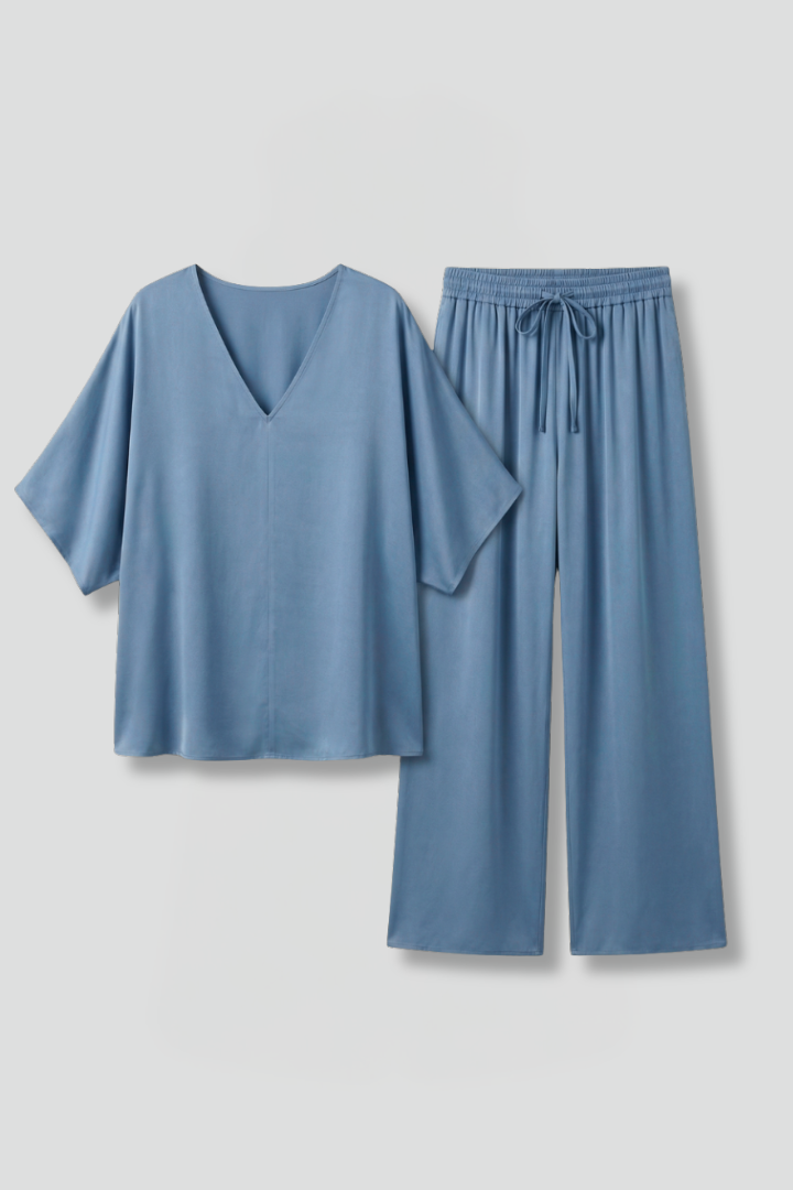 Women’s two-piece trousers set by THE WHITMORE FAMILY featuring black wide-leg pants and a V-neck top.