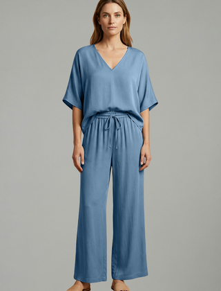 Women’s two-piece trousers set by THE WHITMORE FAMILY featuring black wide-leg pants and a V-neck top, perfect for stylish casual wear.