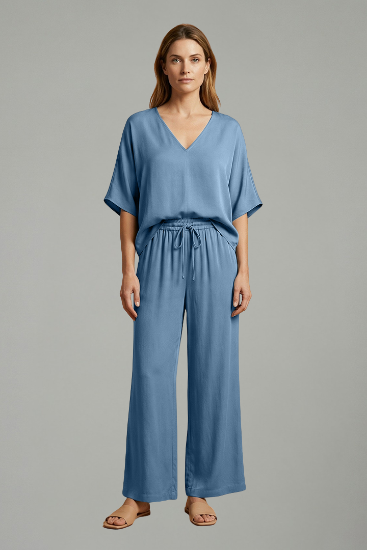 Women’s two-piece trousers set by THE WHITMORE FAMILY featuring black wide-leg pants and a V-neck top, perfect for stylish casual wear.