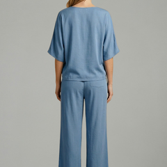 Women’s two piece trousers set by THE WHITMORE FAMILY featuring black wide-leg trousers and a V-neck top.