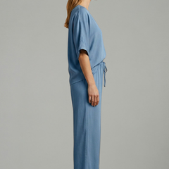 Women’s two-piece trousers set by THE WHITMORE FAMILY featuring a V-neck top and wide-leg black trousers.