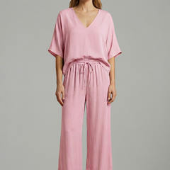 Women’s two-piece trousers set by THE WHITMORE FAMILY featuring a V-neck top and wide-leg black trousers.