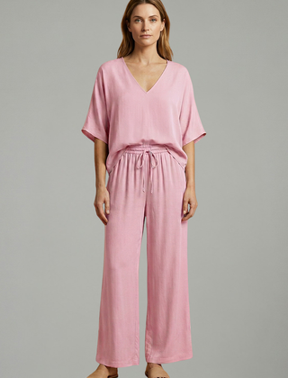 Women’s two-piece trousers set by THE WHITMORE FAMILY featuring a V-neck top and wide-leg black trousers.