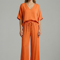 Women’s black two-piece trousers set with V-neck and wide-leg design by THE WHITMORE FAMILY. Stylish and comfortable outfit.