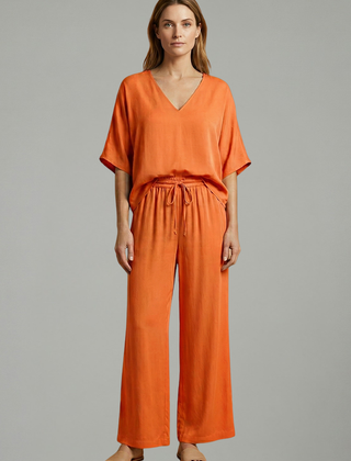 Women’s black two-piece trousers set with V-neck and wide-leg design by THE WHITMORE FAMILY. Stylish and comfortable outfit.