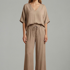 Women’s two-piece trousers set by THE WHITMORE FAMILY featuring a V-neck top and wide-leg pants in black.