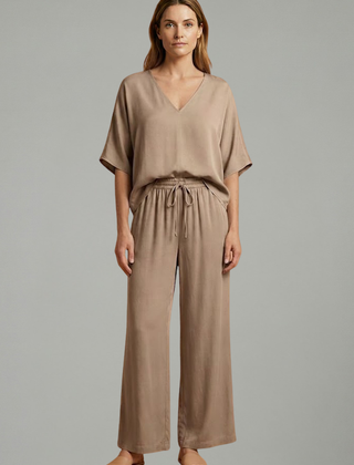 Women’s two-piece trousers set by THE WHITMORE FAMILY featuring a V-neck top and wide-leg pants in black.