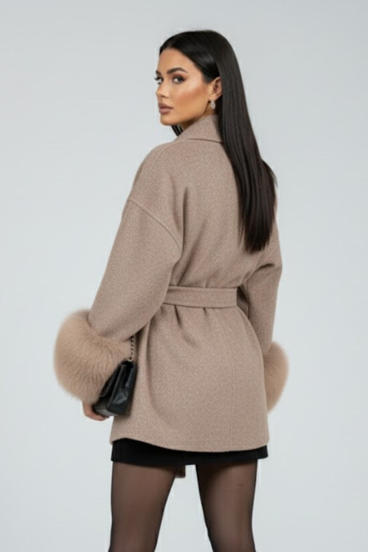 Beige women’s full-length coat with belt and waist tie by THE WHITMORE FAMILY, showcasing a stylish and warm winter jacket.