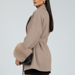 Beige women's full-length belted coat with waist tie from THE WHITMORE FAMILY, featuring a classic jacket design and stylish silhouette.