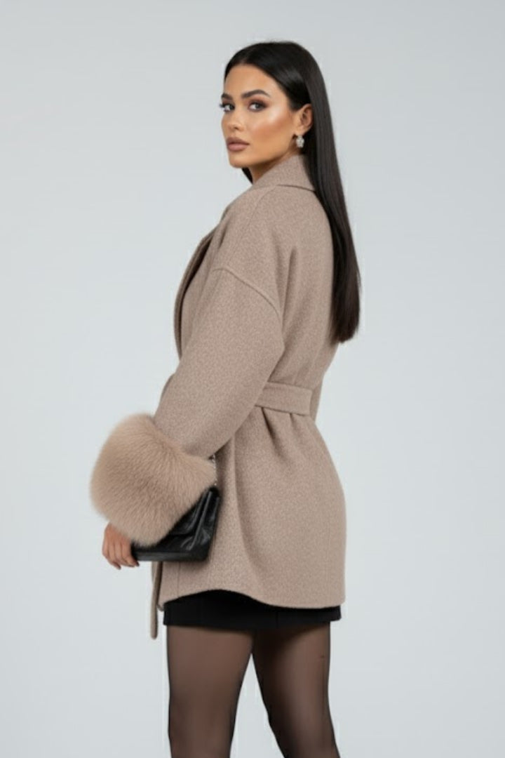 Beige women's full-length belted coat with waist tie from THE WHITMORE FAMILY, featuring a classic jacket design and stylish silhouette.