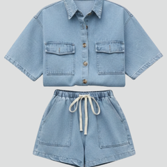 Women’s denim set by THE WHITMORE FAMILY featuring a short-sleeve shirt jacket and matching shorts in subtle blue denim.