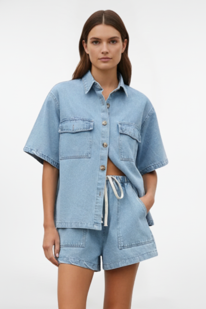 Women’s denim set by THE WHITMORE FAMILY featuring a short-sleeve shirt jacket and matching shorts in subtle blue denim.