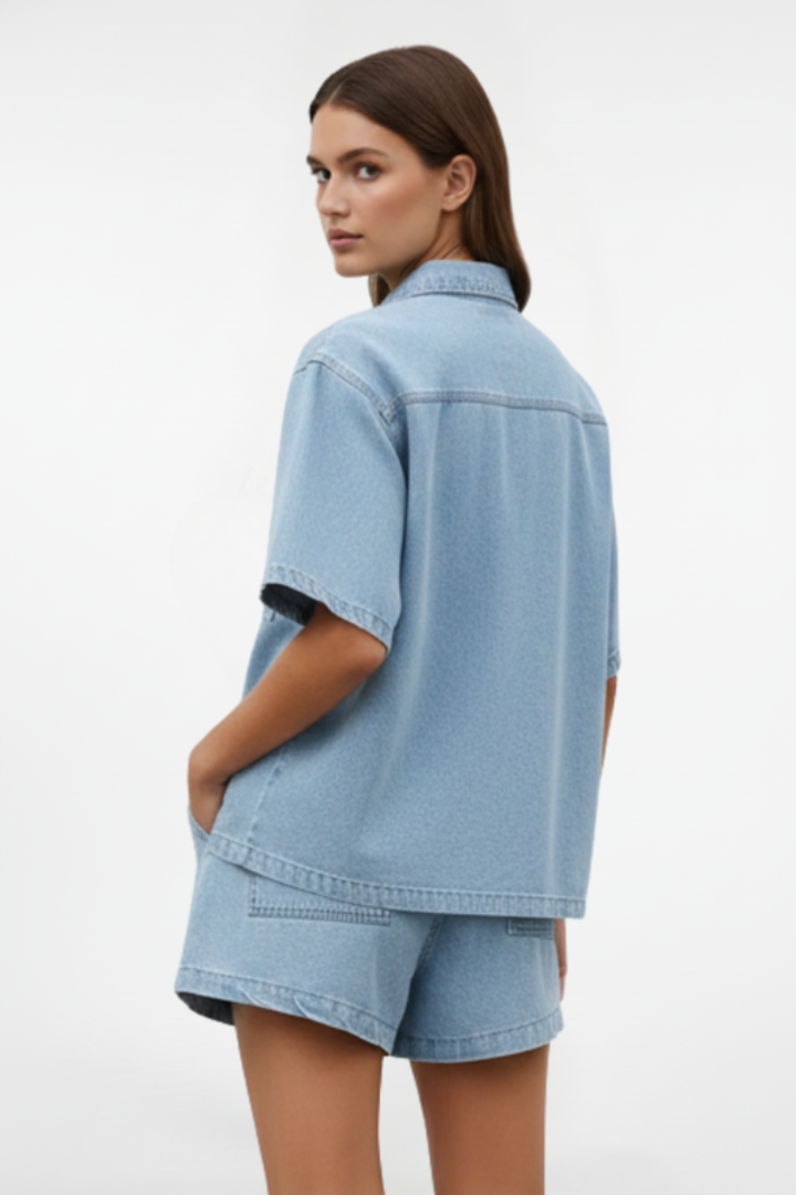 Women’s denim set by THE WHITMORE FAMILY featuring a short-sleeve shirt jacket and matching shorts in subtle blue denim.