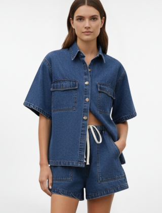 Women’s denim set from THE WHITMORE FAMILY featuring a short-sleeve shirt jacket and matching shorts in subtle blue.