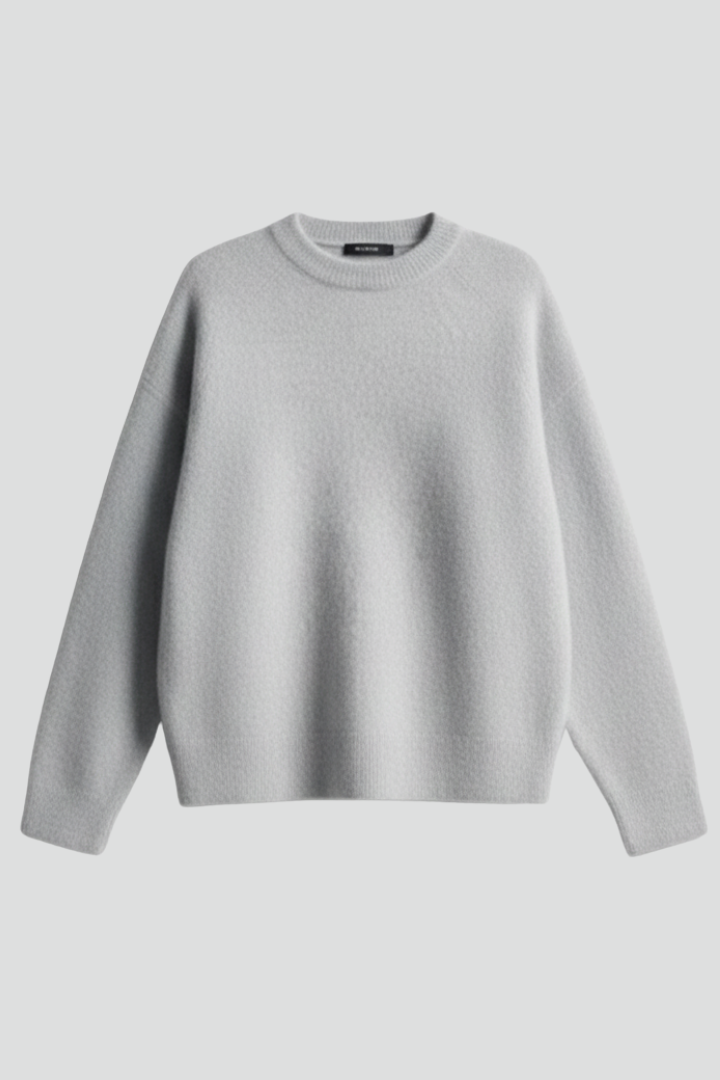 Women’s knitted sweater with round neckline and dropped shoulders, by THE WHITMORE FAMILY, shown on a model, casual and cozy style.