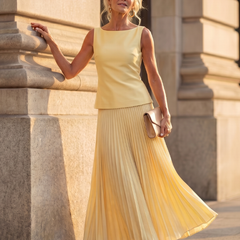 Yellow structured bodice and pleated skirt set by THE WHITMORE FAMILY, featuring a stylish, coordinated fashion ensemble.