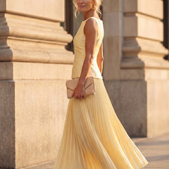 Yellow Rhodes structured bodice and pleated skirt set by THE WHITMORE FAMILY, featuring a fitted top and flowing pleated skirt.