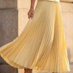 Yellow Rhodes structured bodice and pleated skirt set by THE WHITMORE FAMILY, featuring a fitted bodice and flowing pleated skirt.