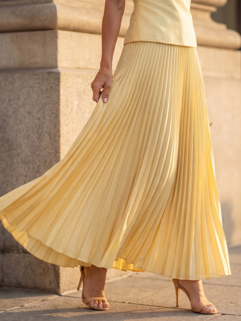 Yellow Rhodes structured bodice and pleated skirt set by THE WHITMORE FAMILY, featuring a fitted bodice and flowing pleated skirt.