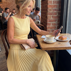 Yellow Rhodes structured bodice and pleated skirt set by THE WHITMORE FAMILY, featuring a fitted bodice and flowing pleated skirt.