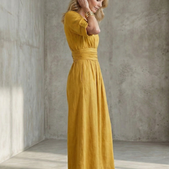 Yellow Wanda cross-front wide-leg jumpsuit by THE WHITMORE FAMILY, featuring a stylish crossover bodice and flowing wide-leg pants.