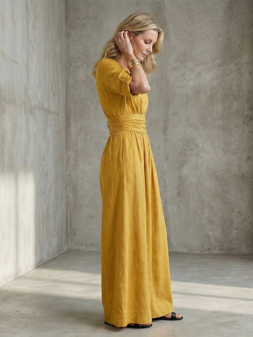 Yellow Wanda cross-front wide-leg jumpsuit by THE WHITMORE FAMILY, featuring a stylish crossover bodice and flowing wide-leg pants.