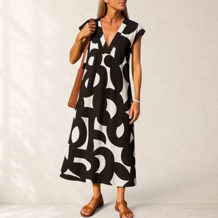 Valery™ flowing V-neck dress by THE WHITMORE FAMILY, lightweight fabric, soft drape, and elegant silhouette in natural pose.