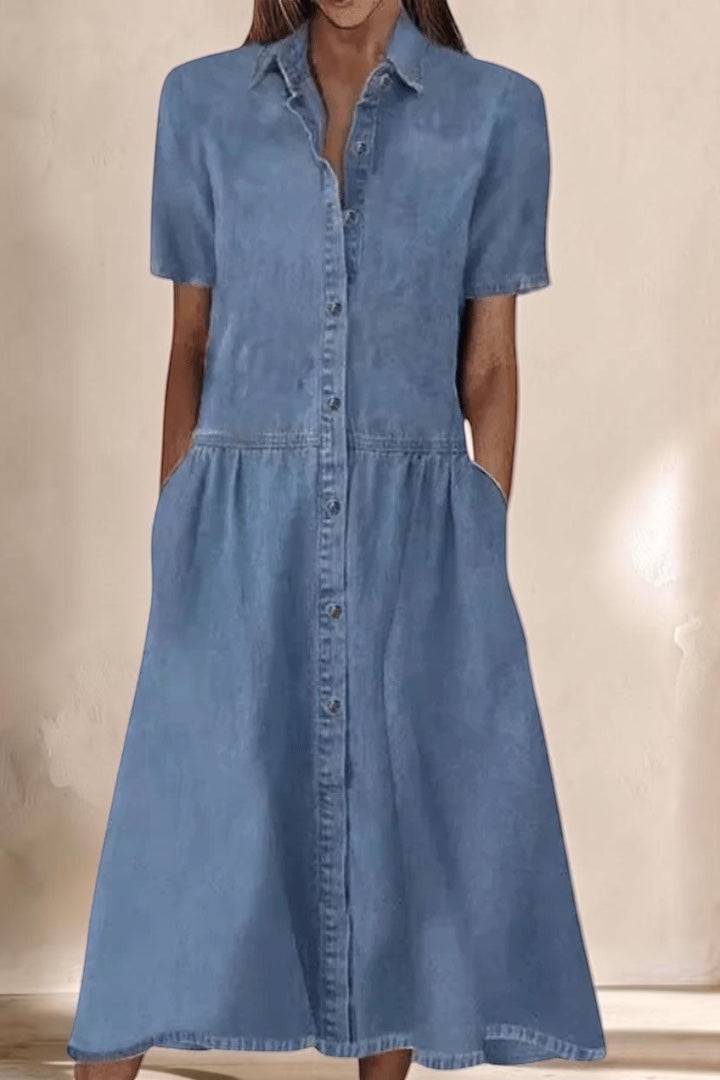 A woman wearing the Aada™ denim midi dress by THE WHITMORE FAMILY, showcasing its stylish fit and classic denim fabric.