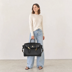 Black Eleanor Weekender bag by THE WHITMORE FAMILY with leather handles and spacious interior for travel and weekend trips.