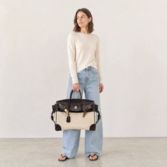 The Eleanor Weekender by THE WHITMORE FAMILY, stylish navy canvas travel bag with leather handles and multiple pockets.